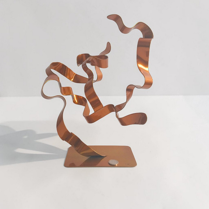 sculpture abstraite arbre ruban acier peint orange avec pièce euro comme échelle