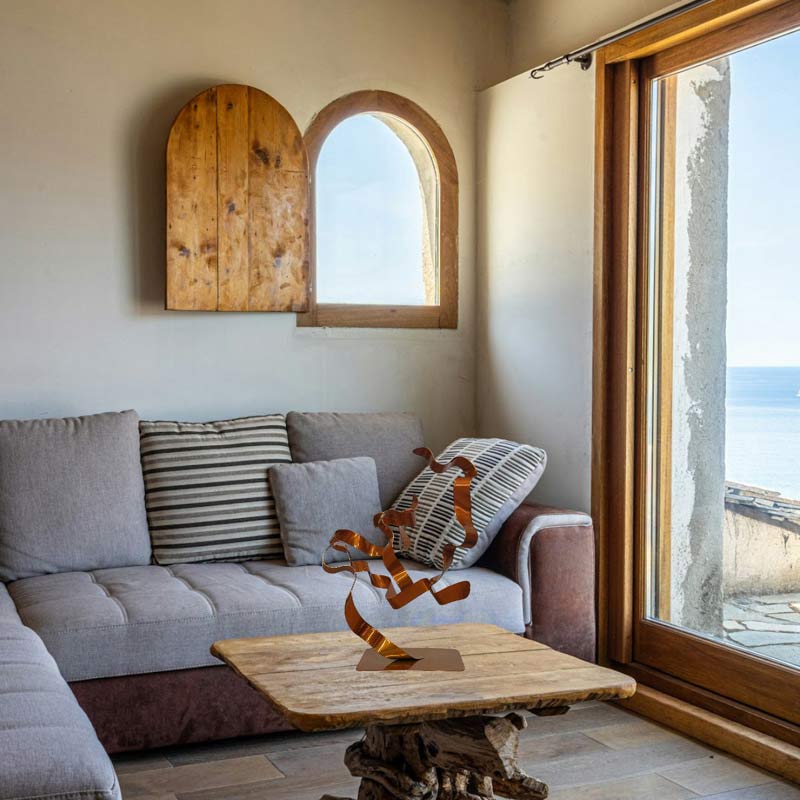 sculpture abstraite arbre ruban acier peint orange dans un salon