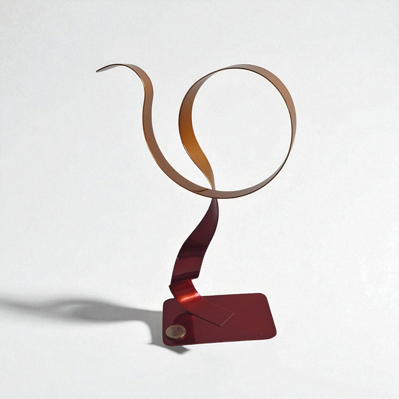 Sculpture métal abstraite rouge et orange NaguraDesign, avec une pièce euro pour échelle