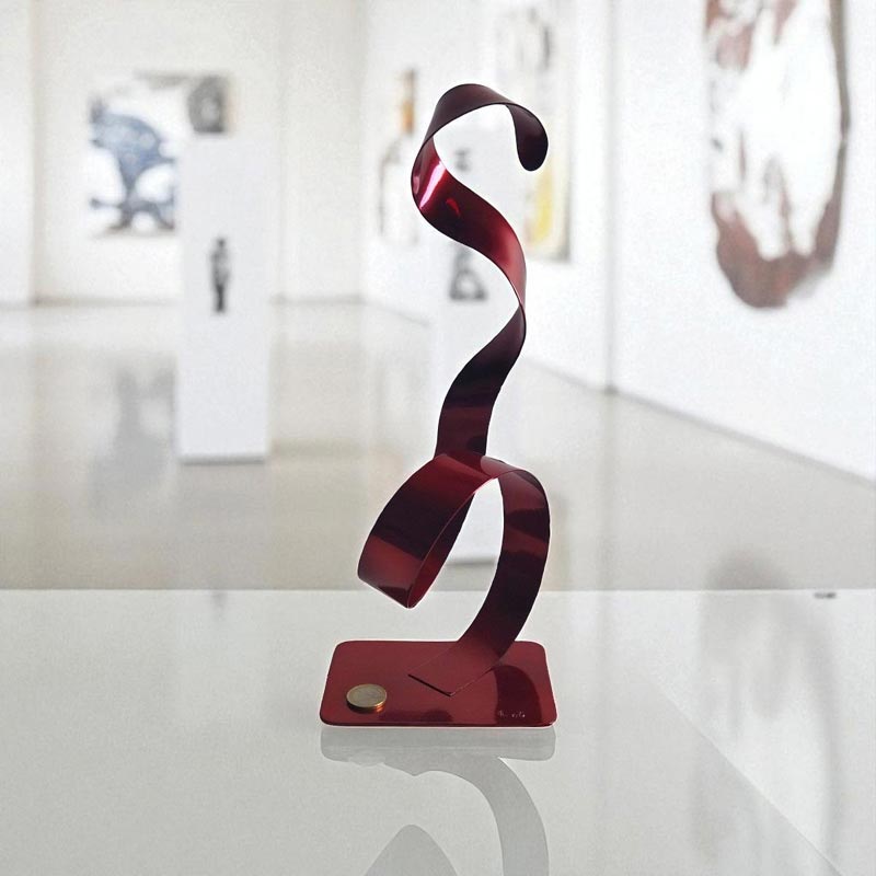 sculpture ruban acier peint rouge contemporaine avec pièce euro comme échelle