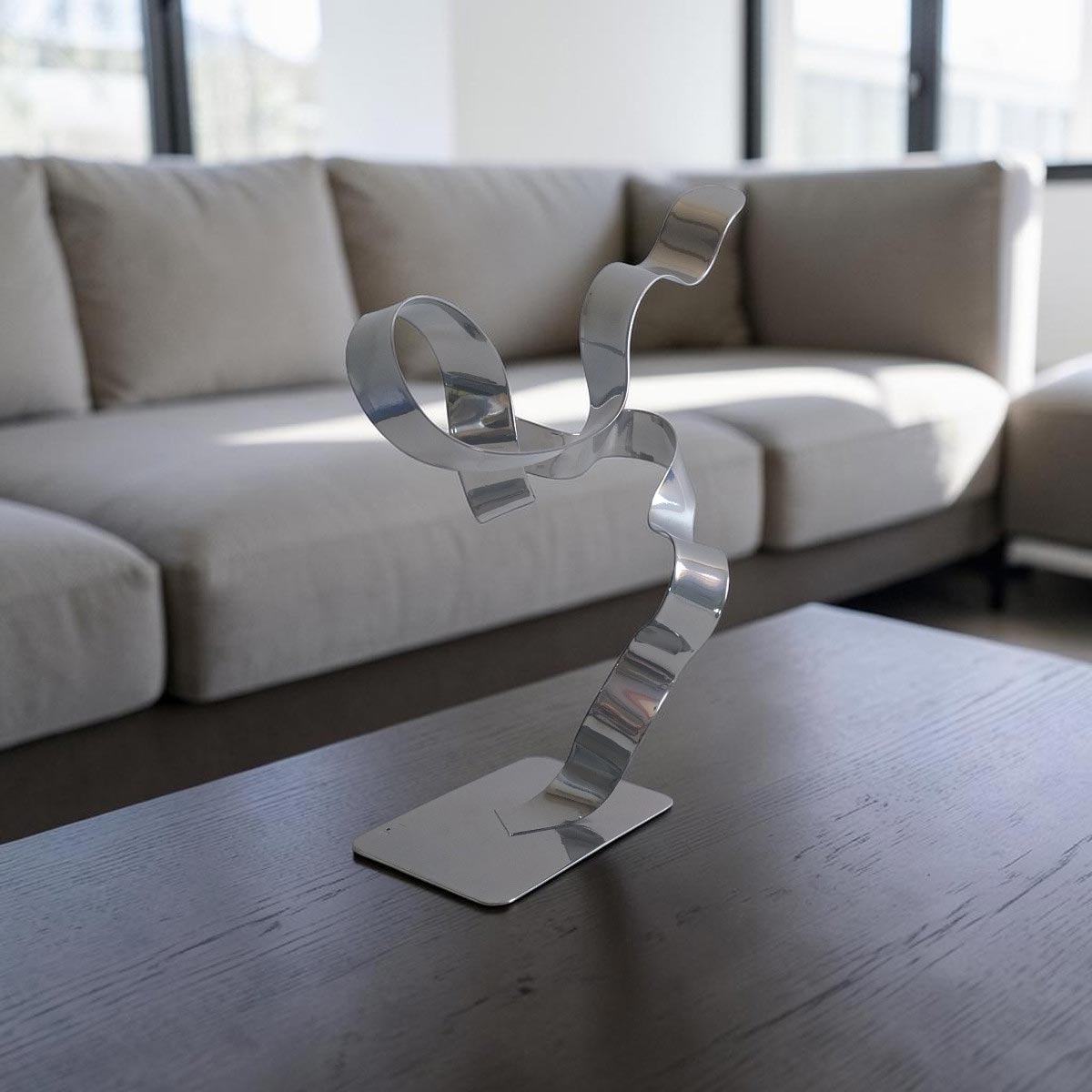 Sculpture ruban abstraite en acier chrome 30 cm – création artisanale contemporaine NaguraDesign situation