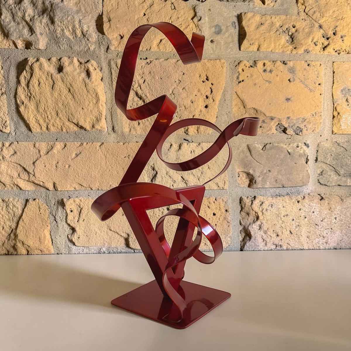 Sculpture GÉO Triangle en métal rouge avec deux rubans 35 cm par NaguraDesign angle