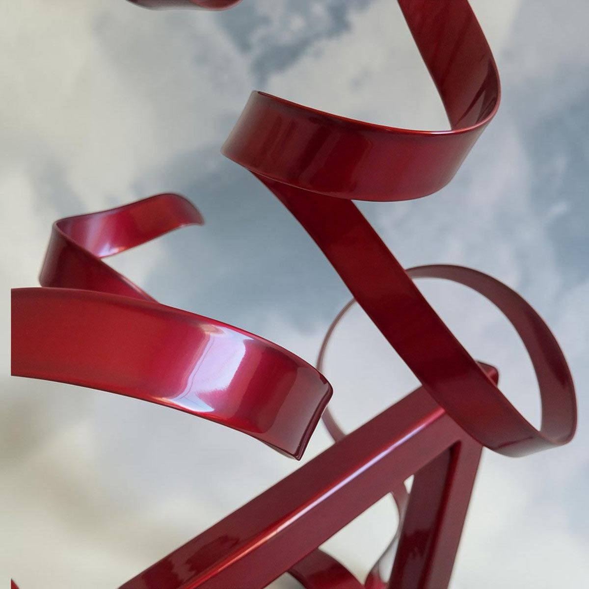 Sculpture GÉO Triangle en métal rouge avec deux rubans 35 cm par NaguraDesign détail