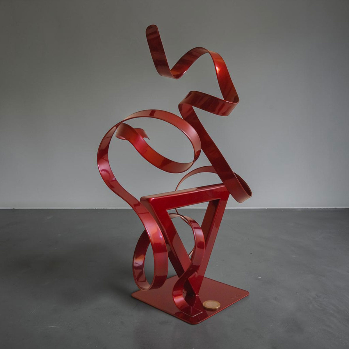 Sculpture GÉO Triangle en métal rouge avec deux rubans 35 cm par NaguraDesign échelle